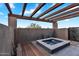 A modern hot tub sits under a wood pergola in this desert backyard at 10354 E Celestial Dr, Scottsdale, AZ 85262