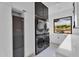 Modern laundry room with stacked washer/dryer, sleek cabinetry, and a view of the desert landscape at 10354 E Celestial Dr, Scottsdale, AZ 85262