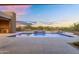 Enjoy resort-style living with a pool, waterfall spa, and outdoor kitchen against a scenic backdrop at 10354 E Celestial Dr, Scottsdale, AZ 85262