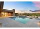 Beautiful backyard featuring a modern pool and spa overlooking the desert landscape at twilight at 10354 E Celestial Dr, Scottsdale, AZ 85262