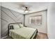 Comfortable bedroom with a patterned accent wall, cozy bed, and natural light from the window at 10778 W Via Del Sol --, Peoria, AZ 85373