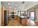 Well-lit kitchen showcasing an island with seating, wood cabinets, stainless steel appliances, and a sliding glass door at 10778 W Via Del Sol --, Peoria, AZ 85373