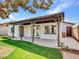 Backyard view of the covered patio, manicured lawn and exterior elevation of the home at 108 W Ivyglen St, Mesa, AZ 85201
