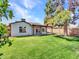 A view of a lush backyard with a mature tree and covered patio at 108 W Ivyglen St, Mesa, AZ 85201