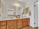 Bright bathroom featuring double sinks, a spacious vanity, and framed mirrors over each sink at 108 W Ivyglen St, Mesa, AZ 85201