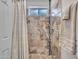 Tiled walk-in shower featuring a convenient shower caddy, adjustable shower head, and glass block window at 108 W Ivyglen St, Mesa, AZ 85201