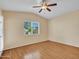 Bright bedroom with ceiling fan, wood floors, and a large window at 108 W Ivyglen St, Mesa, AZ 85201
