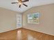 Bedroom with wood floors, ceiling fan, window and access to the backyard at 108 W Ivyglen St, Mesa, AZ 85201
