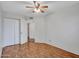 Vacant bedroom featuring hardwood flooring, neutral paint, a ceiling fan, and closet at 108 W Ivyglen St, Mesa, AZ 85201
