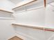 Walk-in closet with built-in wood shelves and hanging rods at 108 W Ivyglen St, Mesa, AZ 85201