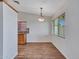 Dining area with wood-look floors, a modern light fixture, and a view of the kitchen at 108 W Ivyglen St, Mesa, AZ 85201