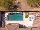 Aerial view of a backyard oasis with a sparkling pool, comfortable seating, and a cozy fire pit area at 11267 E Beck Ln, Scottsdale, AZ 85255