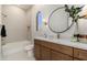 Well-appointed bathroom featuring a large round mirror, marble counters, and a soaking tub at 11267 E Beck Ln, Scottsdale, AZ 85255