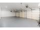 Large three car garage with gray epoxy flooring and multiple garage door access points at 11267 E Beck Ln, Scottsdale, AZ 85255