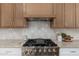 A gourmet kitchen features stainless steel appliances, tile backsplash, and custom cabinets at 11267 E Beck Ln, Scottsdale, AZ 85255