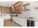 Spacious kitchen with custom cabinets, wine fridge, floating shelves, modern tile backsplash, and stainless steel appliances at 11267 E Beck Ln, Scottsdale, AZ 85255