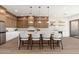 Modern kitchen featuring an island bar with seating, stylish pendant lighting, and stainless steel appliances at 11267 E Beck Ln, Scottsdale, AZ 85255