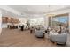 Bright open-concept living area featuring a chandelier, modern furnishings, and seamless indoor-outdoor flow to the patio at 11267 E Beck Ln, Scottsdale, AZ 85255