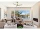 Bright living room with large windows overlooking the pool area, a fireplace, and stylish furnishings at 11267 E Beck Ln, Scottsdale, AZ 85255