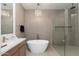 Spa-like bathroom with freestanding tub, glass enclosed shower, and modern fixtures at 11267 E Beck Ln, Scottsdale, AZ 85255
