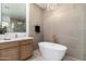 Spa-like bathroom featuring a freestanding tub, elegant chandelier and designer fixtures at 11267 E Beck Ln, Scottsdale, AZ 85255