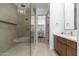 Light filled main bathroom featuring wooden cabinets, soaking tub, and glass enclosed shower at 11267 E Beck Ln, Scottsdale, AZ 85255