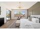 Bright main bedroom with a view to the pool, stylish chandelier, and plenty of natural light at 11267 E Beck Ln, Scottsdale, AZ 85255
