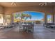 Inviting covered patio with comfortable seating and picturesque views of the surrounding landscape and community pool at 11267 E Beck Ln, Scottsdale, AZ 85255