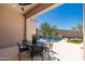 Covered patio with stone pavers, outdoor furniture and an in-ground pool overlooking the landscape at 11267 E Beck Ln, Scottsdale, AZ 85255