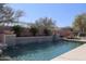 Backyard pool featuring tiled waterfall, surrounding fence, and lounge furniture at 11267 E Beck Ln, Scottsdale, AZ 85255