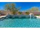 Beautiful pool with blue tile accents and cascading waterfalls, surrounded by lush greenery at 11267 E Beck Ln, Scottsdale, AZ 85255