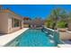 A tranquil pool with water features, complemented by the home's architecture and desert landscape at 11267 E Beck Ln, Scottsdale, AZ 85255