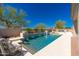 Inviting pool area featuring tiled waterfalls, mature trees and lounge seating for outdoor enjoyment at 11267 E Beck Ln, Scottsdale, AZ 85255