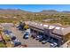 Aerial of shopping center with multiple storefronts, convenient parking, and mountain views in a desert landscape at 11267 E Beck Ln, Scottsdale, AZ 85255