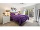 Bright bedroom features a cozy queen bed with purple bedding and a sliding door to the outdoor patio at 1173 E Beryl Ave, Phoenix, AZ 85020