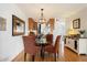 Cozy dining area with a modern chandelier, seating for four, and seamless access to the kitchen at 1173 E Beryl Ave, Phoenix, AZ 85020