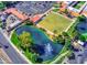 Aerial view of community amenities: bowling green, pond with fountain, and parking at 1202 Leisure World --, Mesa, AZ 85206