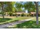 Charming single-story home with a tile roof, surrounded by lush greenery and a well-manicured lawn at 1202 Leisure World --, Mesa, AZ 85206