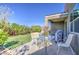 Backyard with artificial grass, landscaping, and outdoor dining table and chairs on the patio at 1280 W Blue Ridge Dr, San Tan Valley, AZ 85140
