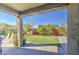 Covered patio overlooking backyard with artificial grass, garden area, and mature landscaping at 1280 W Blue Ridge Dr, San Tan Valley, AZ 85140