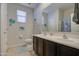 Well-lit bathroom features double sinks, tropical decor, and a shower with a privacy curtain at 1280 W Blue Ridge Dr, San Tan Valley, AZ 85140