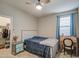 Cozy bedroom features a ceiling fan, bedside table, closet and a desk, ideal for a  at 1280 W Blue Ridge Dr, San Tan Valley, AZ 85140