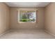 Bright bedroom with a large window offering outdoor views and neutral carpet at 13284 W Aleppo Dr, Sun City West, AZ 85375
