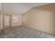 Bright living room featuring plush gray carpet, neutral walls, and ample natural light from the window with privacy blinds at 13284 W Aleppo Dr, Sun City West, AZ 85375
