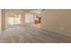 Spacious living room with sliding glass doors to patio, neutral carpet and walls, and an open view to the kitchen at 13284 W Aleppo Dr, Sun City West, AZ 85375