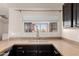 Well-lit kitchen with granite countertops, stainless steel sink, and dark cabinetry, offers an efficient workspace at 1633 E Lakeside Dr # 106, Gilbert, AZ 85234