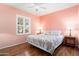 Cozy bedroom with hardwood floors, a queen-size bed, and bright natural light through shuttered windows at 16564 W Wild Horse Way, Surprise, AZ 85387