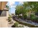 Front yard featuring desert landscaping, decorative water feature, and mature trees at 16564 W Wild Horse Way, Surprise, AZ 85387