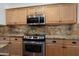 Close up of a well-equipped kitchen with light wood cabinets and granite countertops at 16564 W Wild Horse Way, Surprise, AZ 85387