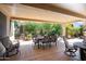 Large covered patio featuring an outdoor table and lush backyard at 16564 W Wild Horse Way, Surprise, AZ 85387